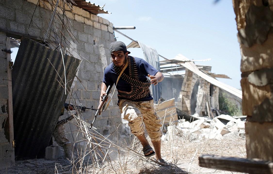 Soldado da Força Líbia, apoiada pela ONU, tenta se proteger durante confronto com o Estado Islâmico, em Sirte, na Líbia