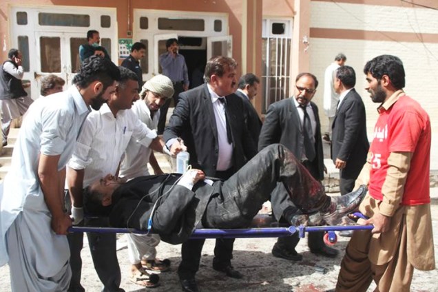Voluntários e socorristas carregam homem ferido após explosão em hospital de Quetta, no Paquistão. Ao menos 63 pessoas morreram - 08/08/2016