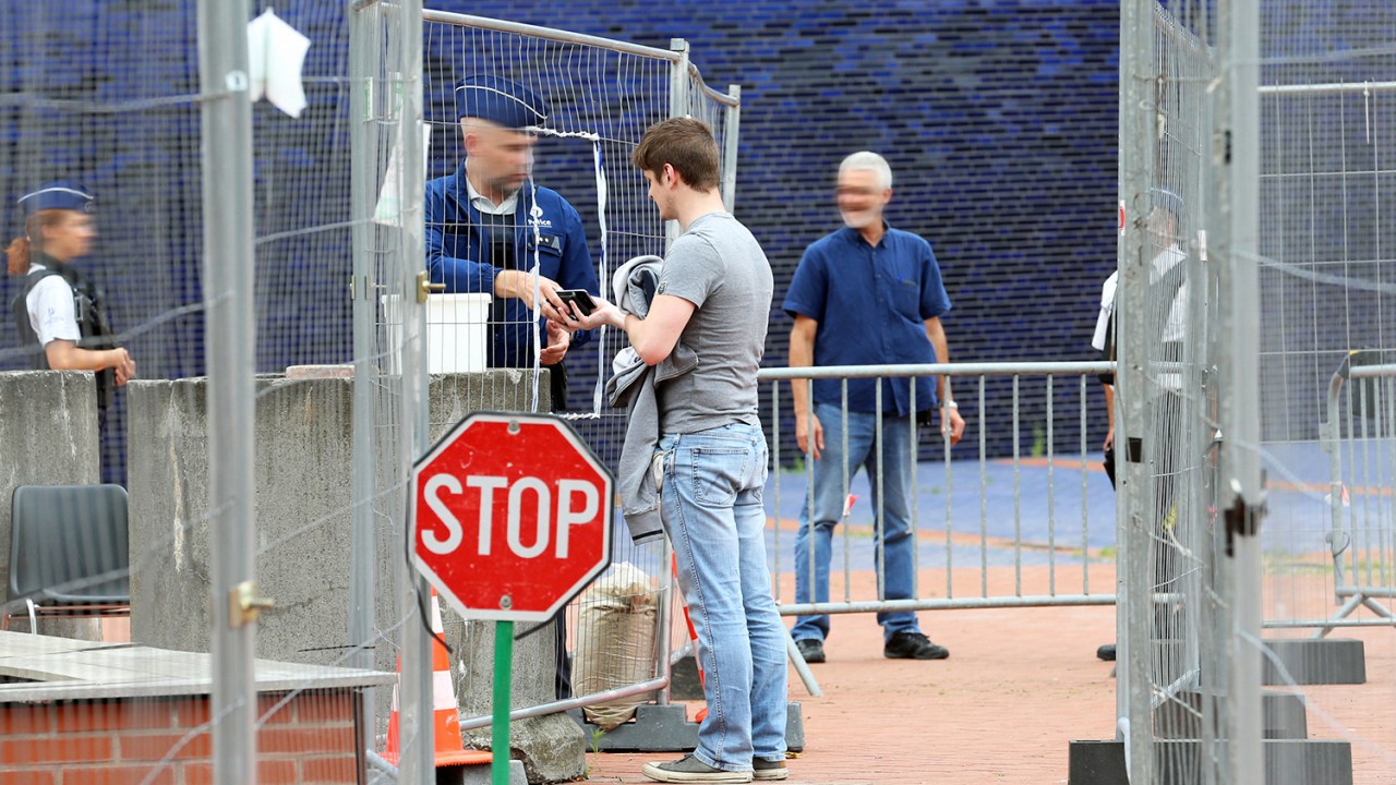 Policial belga revista pessoas, como medida de segurança, após um homem armado com um facão atacar duas policiais, em Charleroi