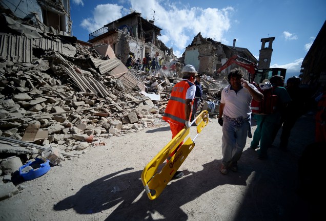 Moradores da cidade italiana de Amatrice, caminham próximos à prédios destruídos por forte terremoto - 24/08/2016