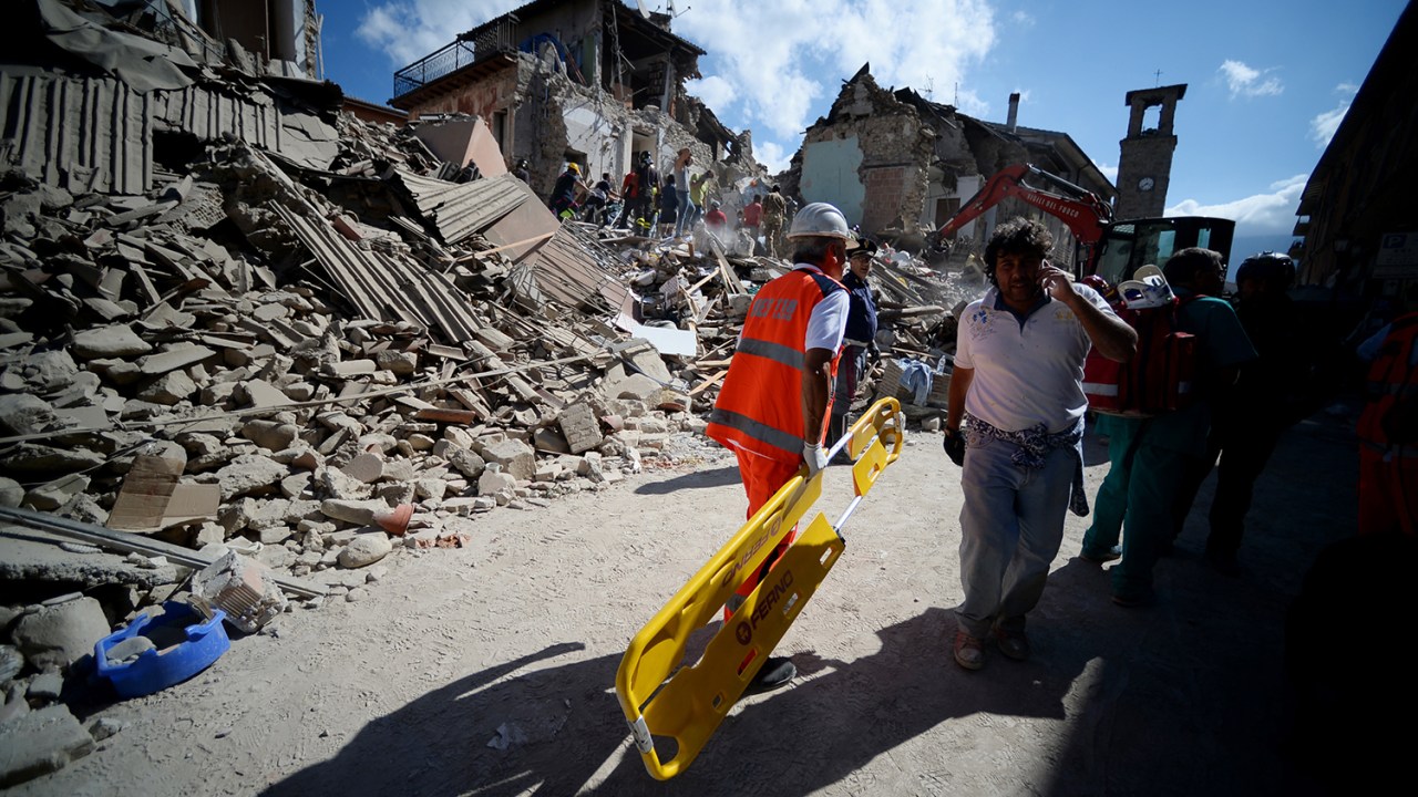Moradores da cidade italiana de Amatrice, caminham próximos à prédios destruídos por forte terremoto - 24/08/2016