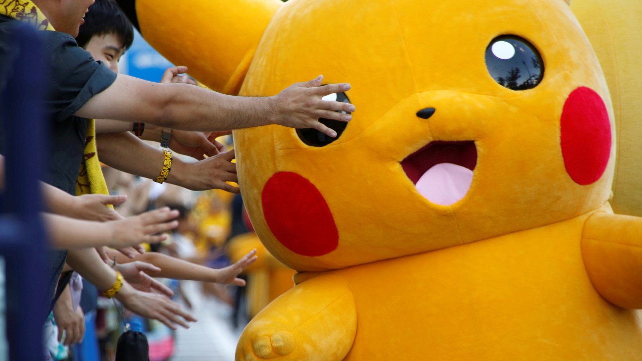 Pessoas fantasiadas de Pikachu desfilam por uma avenida no centro de Yokohama, no Japão