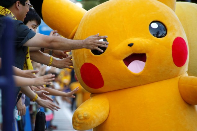Pessoas fantasiadas de Pikachu desfilam por uma avenida no centro de Yokohama, no Japão