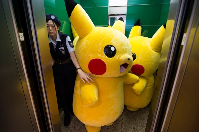 Atores vestidos de Pikachu entram em um elevador pouco antes de se apresentarem no desfile da cidade de Yokohama, no Japão
