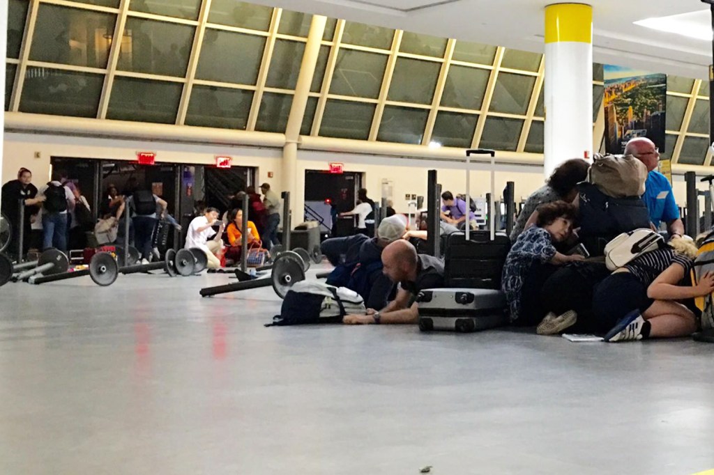 Passageiros se abaixam em terminal do aeroporto John F.Kennedy, após falso alerta de tiros no local - 14/08/2016