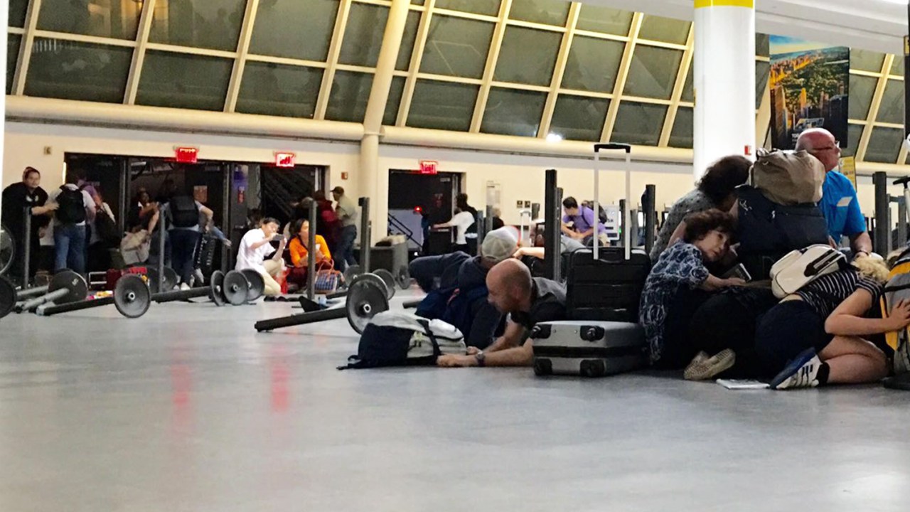 Passageiros se abaixam em terminal do aeroporto John F.Kennedy, após falso alerta de tiros no local - 14/08/2016