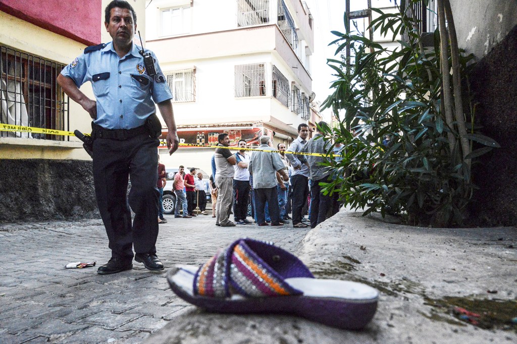 Policial turco é visto próximo a uma sandália, no local onde ataque durante uma festa de casamento deixou ao menos 50 mortos e 100 feridos, na cidade de Gaziantep, no sudeste da Turquia - 21/08/2016