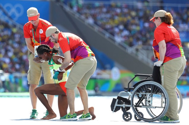 Paramédicos levam cadeira de rodas até Etensh Diro, corredora etíope que correu a prova de 3000m com obstáculos com o pé direito descalço, após perder a sapatilha durante a prova - 13/08/2016