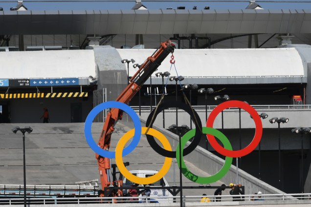 Trabalhadores instalam os anéis olímpicos no estádio do Maracanã horas antes da cerimônia de abertura dos Jogos Olímpicos Rio 2016
