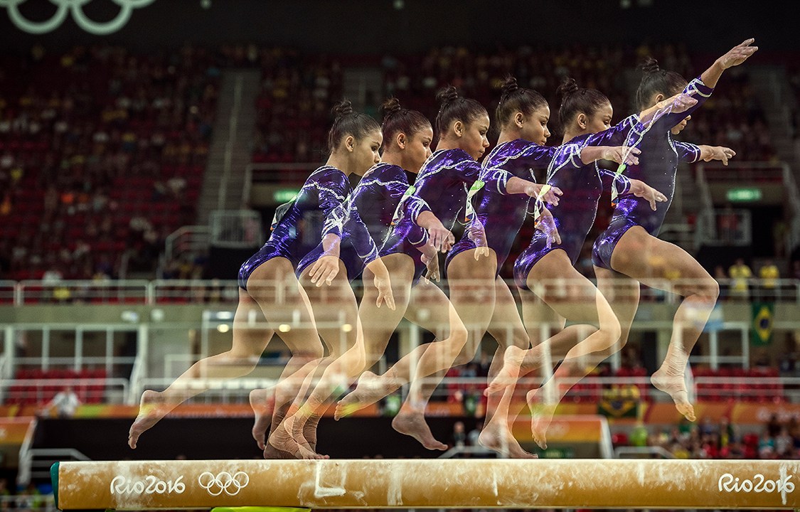 Ginastas se apresentam na trave de equilíbrio durante etapa classificatória da ginástica artística feminina, disputada na Arena Olímpica da Barra