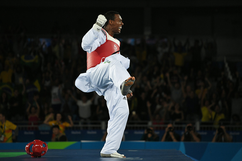 Brazil's Maicon Siqueira celebrates after winning against Great Britain's Mahama Cho in their men's taekwondo bronze medal bout in the +80kg category as part of the Rio 2016 Olympic Games, on August 20, 2016, at the Carioca Arena 3, in Rio de Janeiro. / AFP PHOTO / Ed JONES