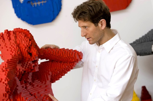 Homem observa estátua feita inteiramente de Legos