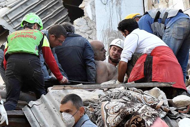 Sobrevivente é retirado de escombros, após um terremoto de magnitude 6.2 atingir a cidade de Amatrice, na Itália