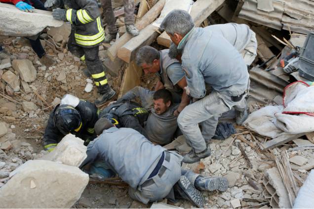 Bombeiros e civis resgatam um homem em Amatrice, na Itália, após forte terremoto atingir a região - 24/08/2016