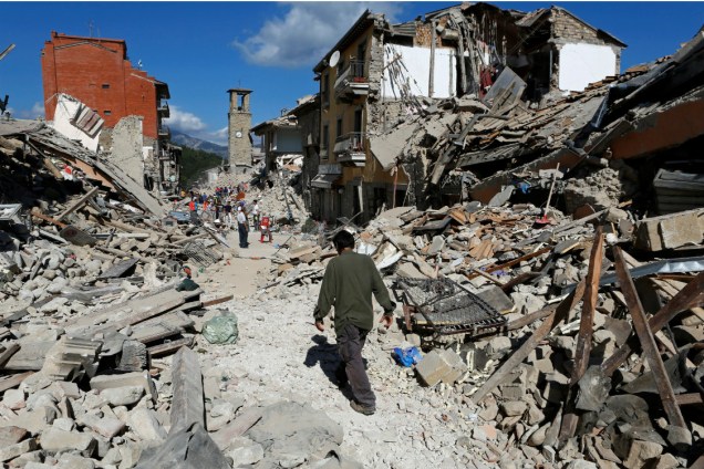 Um homem caminha sobre escombros em Pescara del Trento, na Itália