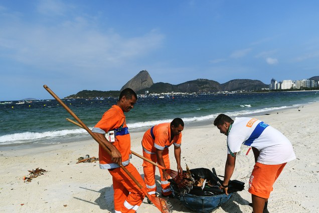 Garis recolhem o lixo da praia do Flamengo, no Rio de Janeiro