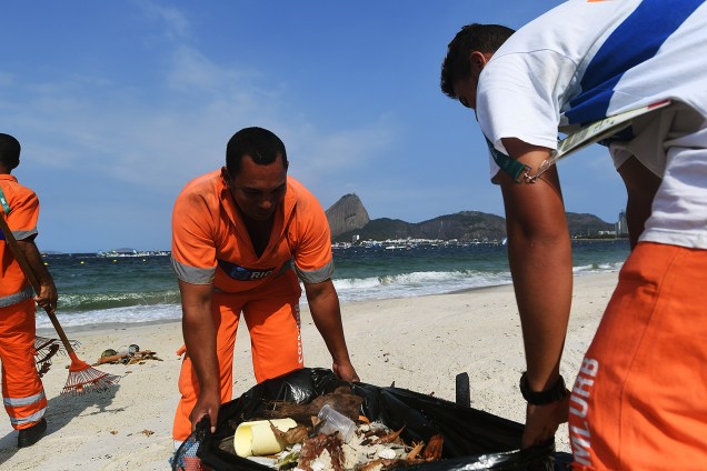 Garis recolhem o lixo da praia do Flamengo, no Rio de Janeiro