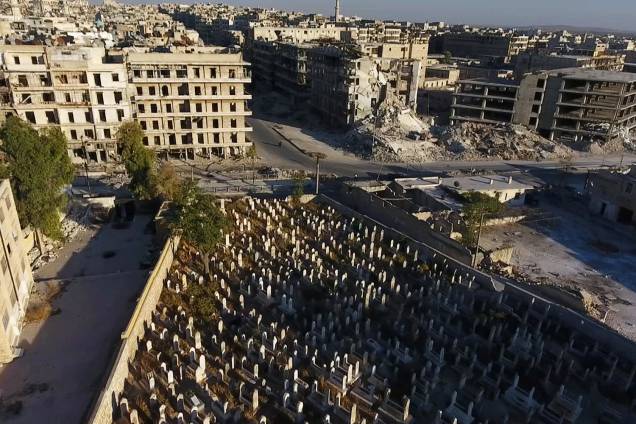 Imagem mostra um cemitério rodeado por prédios destruídos em uma área controlada por rebeldes na cidade de Alepo, na Síria - 27-09-2016