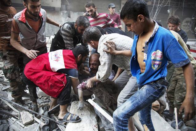 Um homem se desespera ao ver o corpo de sua filha do meio dos destroços de um prédio após um bombardeio no bairro de Al-Shaar em Alepo, na Síria - 27-09-2016