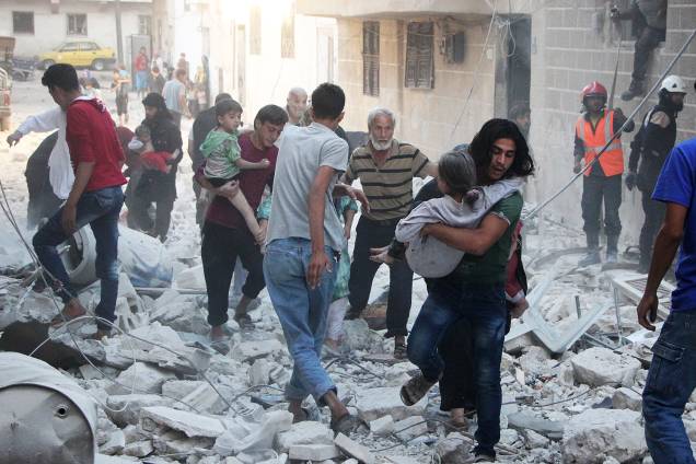 Equipes de resgate buscam sobreviventes no local de um bombardeio na cidade de Idlib , na Síria - 29-09-2016