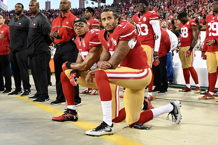 Colin Kaepernick (dir) e Eric Reid (esq), do San Francisco 49ers, ajoelham em forma de protesto durante a execução do hino nacional americano, antes de partida válida pela NFL - 12/09/2016