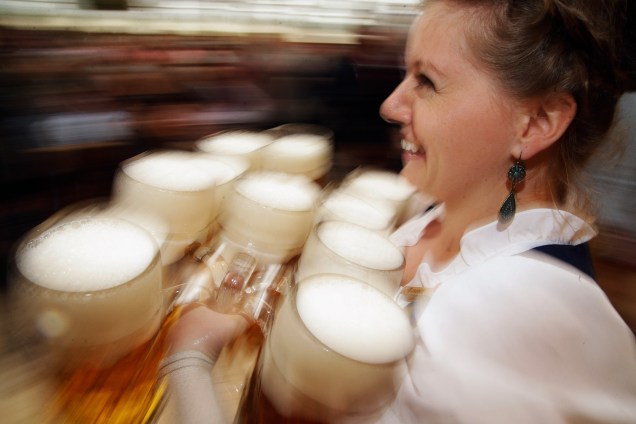 Garçonete carrega várias canecas de cerveja em uma das tendas para visitantes e foliões da Oktoberfest, montadas no Theresienwiese, centro de Munique, sul da Alemanha