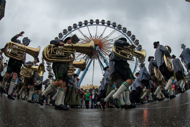 Banda desfila em frente a uma roda gigante durante a Oktoberfest em Munique, na Alemanha