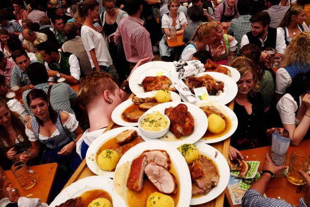 Garçonete carrega pratos de comidas típicas alemãs durante festival do Oktoberfest, em Munique, Alemanha