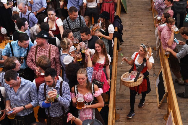 Centenas de visitantes apreciam comidas tradicionais alemãs e milhares de litros de cerveja durante a Oktoberfest, em Munique
