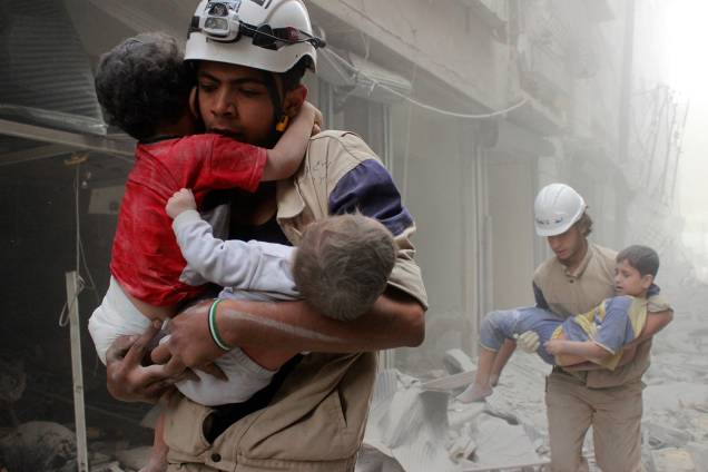 Membros da defesa civil resgatam crianças vítimas de um ataque aéreo que atingiu região vizinha a Alepo, na Síria - 16/09/2016