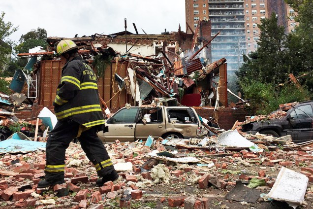 Bombeiro americano caminha em meio aos destroços de uma casa, após explosão no bairro do Bronx, em Nova York - 27/09/2016