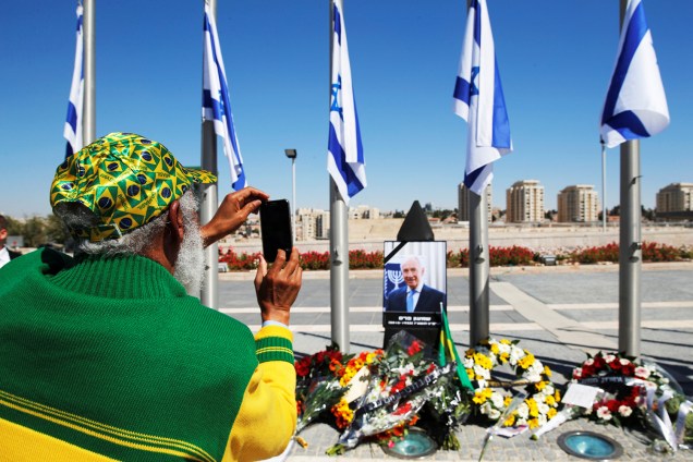 Homem fotografa retrato do ex-presidente israelense Shimon Peres, em Jerusalém - 29/09/2016
