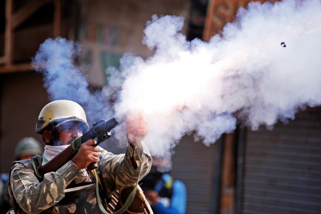 Policial indiano dispara bombas de gás lacrimogêneo para dispersar manifestantes durante protesto em Srinagar, na região da Caxemira - 13/09/2016