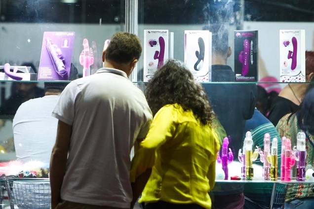 Casal olha produtos na vitrine durante feira erótica ÍNTIMI expo, em São Paulo