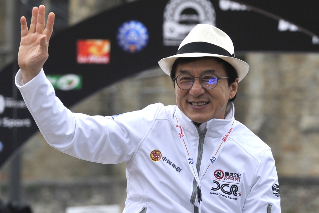 Ator chinês Jackie Chan cumprimenta fãs durante Parada Automobilística, na França