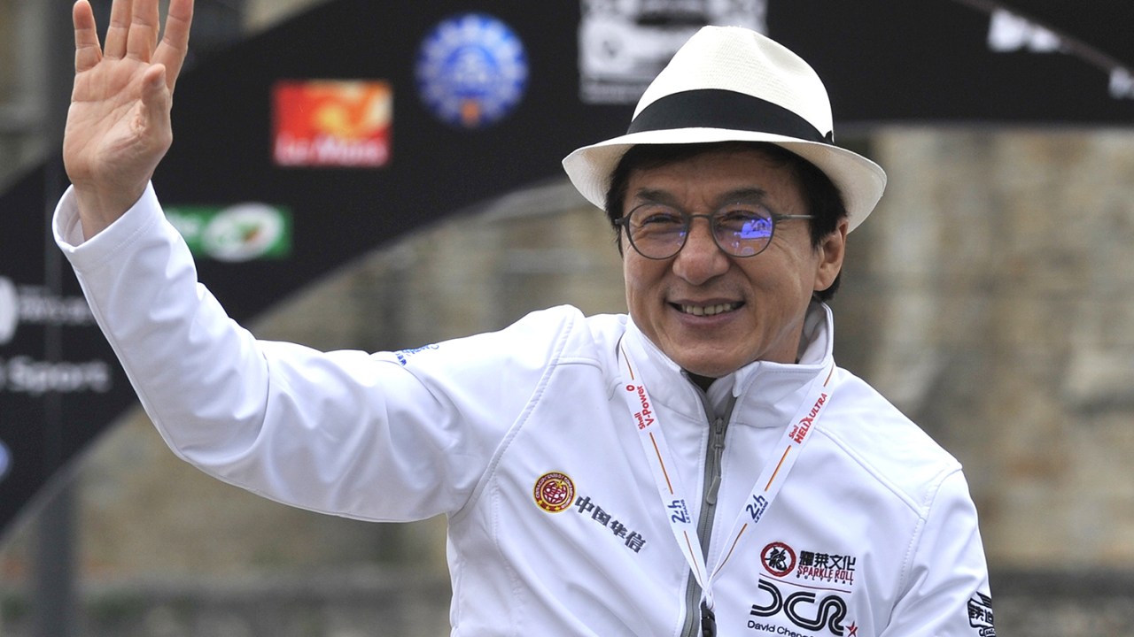 Ator chinês Jackie Chan cumprimenta fãs durante Parada Automobilística, na França