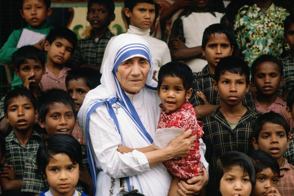 Madre Teresa acompanhada de crianças em seu local de missão em Calcutá, na Índia - 1980