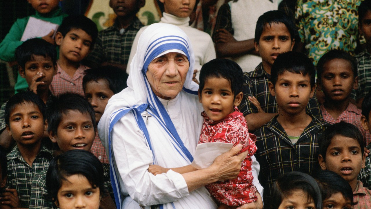 Madre Teresa acompanhada de crianças em seu local de missão em Calcutá, na Índia - 1980