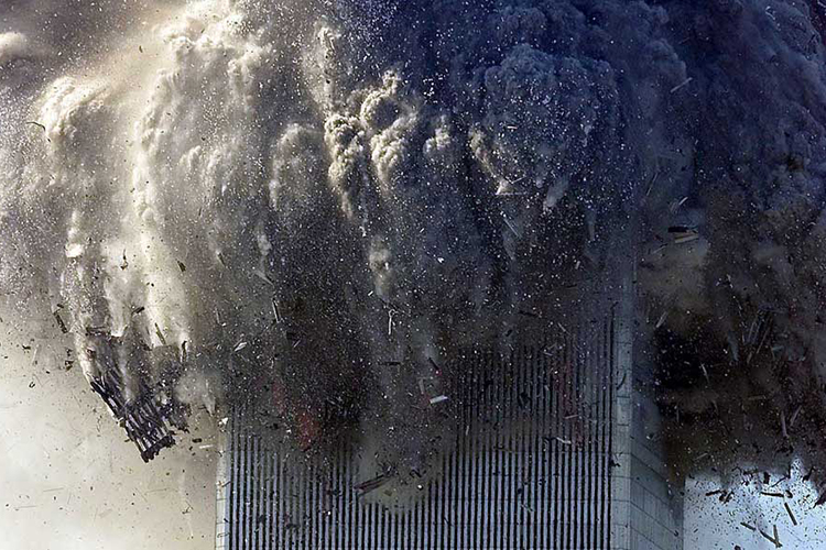 Torre do World Trade Center desaba e cobre a Ilha de Manhattan de poeira e fumaça tóxica. Na manhã do dia 11 de setembro de 2001, dois aviões comerciais foram sequestrados no Aeroporto de Boston por terroristas da Al Qaeda, e instantes depois atingiram intencionalmente as duas torres do maior complexo comercial do planeta