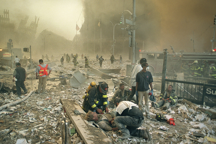 Bombeiros e paramédicos auxiliam feridos após os atentados terroristas ao World Trade Center, na Ilha de Manhattan, em Nova York. Na manhã do dia 11 de setembro de 2001, dois aviões comerciais foram sequestrados no Aeroporto de Boston por terroristas da Al Qaeda, e instantes depois atingiram intencionalmente as duas torres do maior complexo comercial do planeta