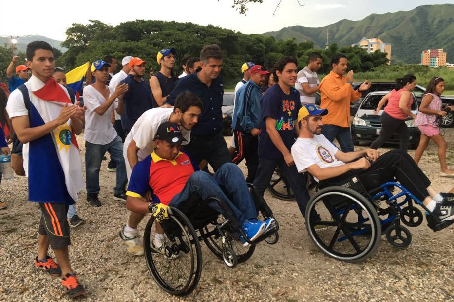 Manifestantes de oposição pedem a saída do presidente venezuelano de Nicolás Maduro, em Caracas