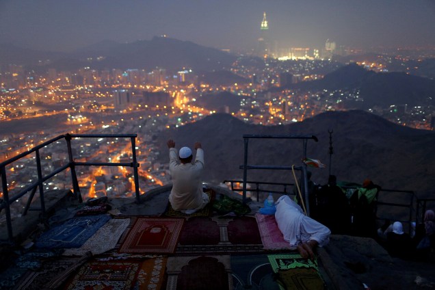 Muçulmano reza e observa a cidade de Meca no topo do monte Al-Noor. Acredita-se que foi neste topo onde o profeta Maomé recebeu as primeiras instruções do Corão