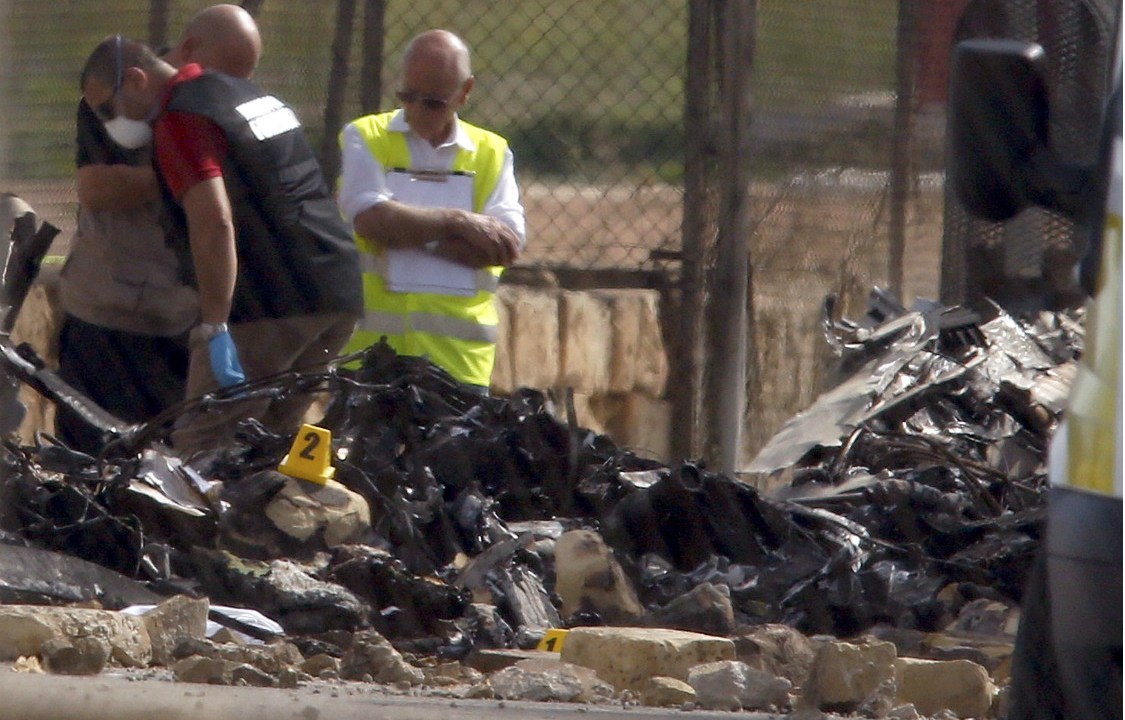 Funcionários inspecionam os destroços do avião que explodiu no ar, em Malta