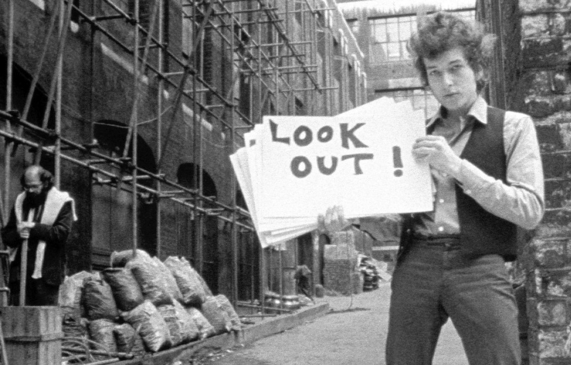 Bob Dylan durante o clipe "Subterranean Homesick Blues", com Allen Ginsberg ao fundo