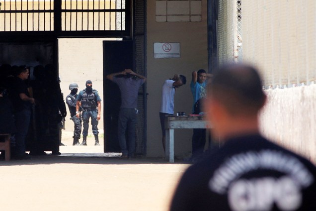 Policiais revistam presos na Penitenciária Agrícola de Monte Cristo, em Boa Vista (RR), após rebelião no local deixar dezenas de mortos - 17/10/2016