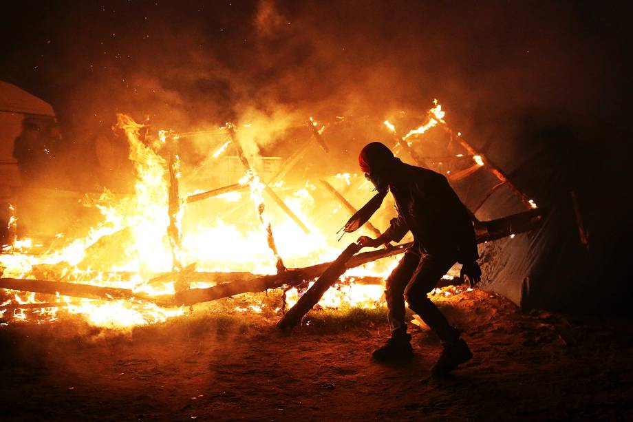 Migrantes são fotografados no campo de refugiados conhecido como 'Selva' em Calais, na França. Os migrantes estão sendo transferidos para centros de acolhimento espalhados pelo país - 25-10-2016