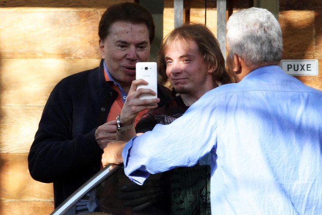 O apresentador Silvio Santos tira selfie com fã ao chegar no salão do Jassa - 06/08/2016