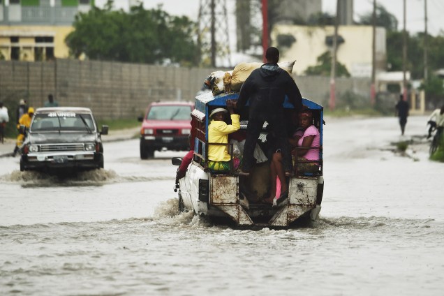 Carros atravessam rua inundada na capital haitiana após as fortes chuvas ocasionadas pelo furacão Matthew - 04-10-2016