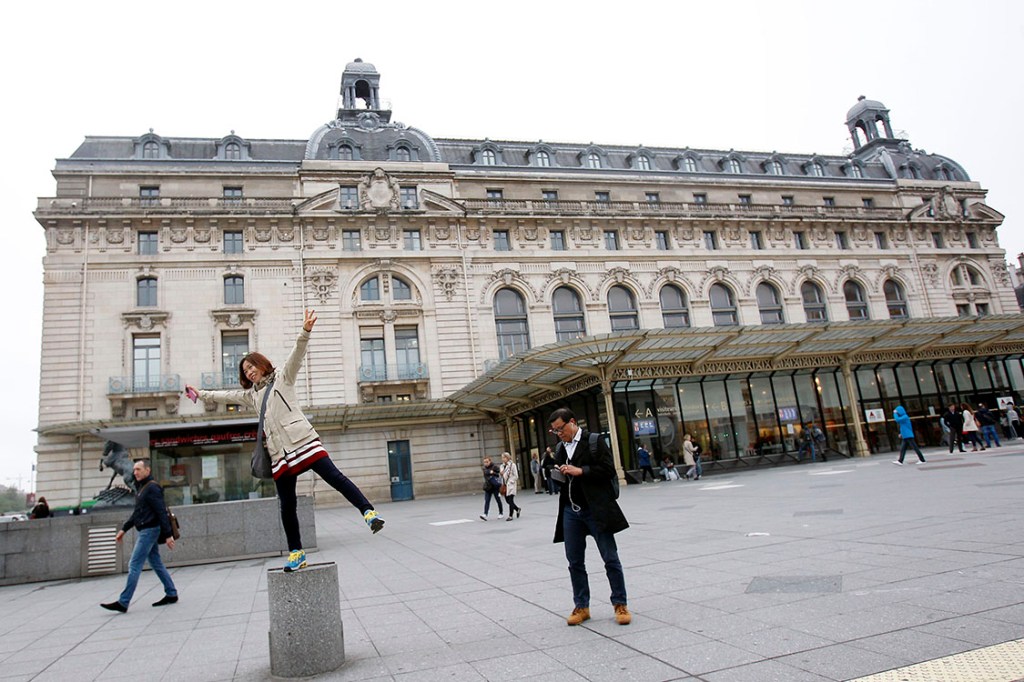 Turista se diverte em frente ao Museu d'Orsay, em Paris