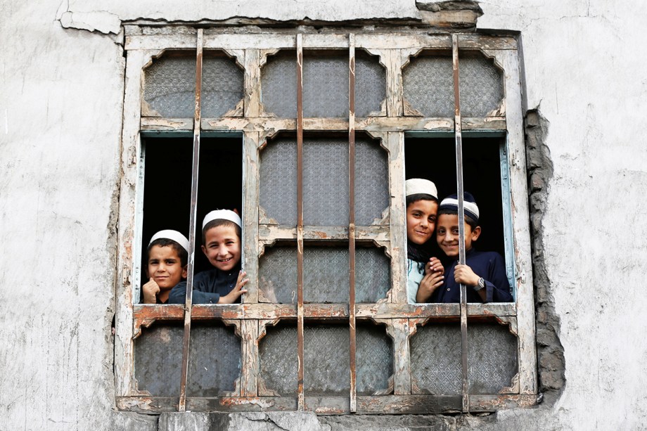Estudantes de escola religiosa observam através de uma janela, em Cabul, no Afeganistão - 05/10/2016